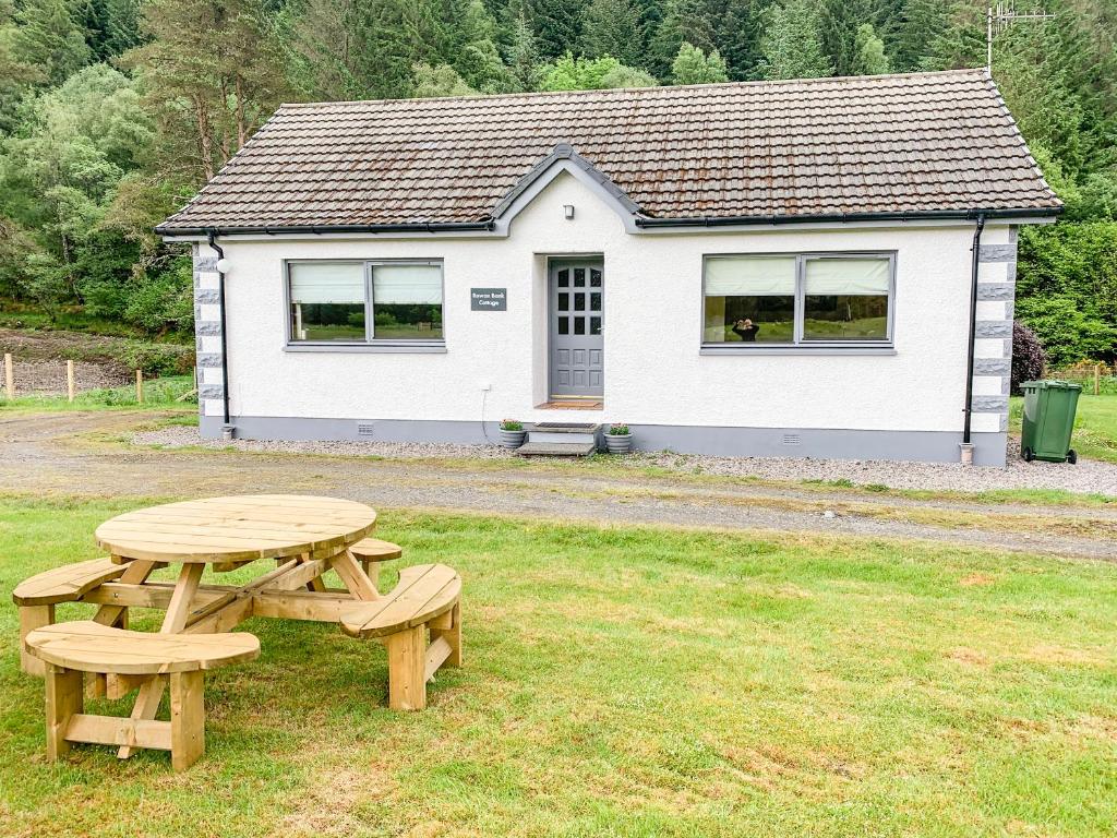 a picnic table and bench in front of a house at Rowan Bank in Spean Bridge