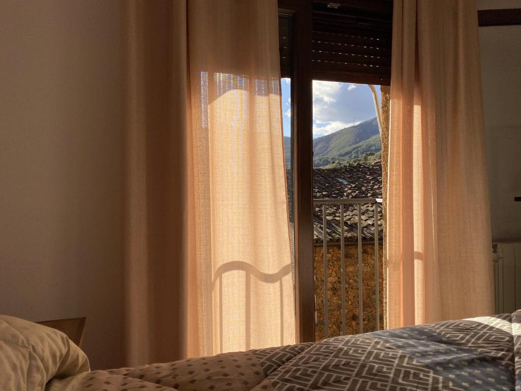 a bedroom with a window with a view of a mountain at Casa Senagüilla in Robledillo de Gata