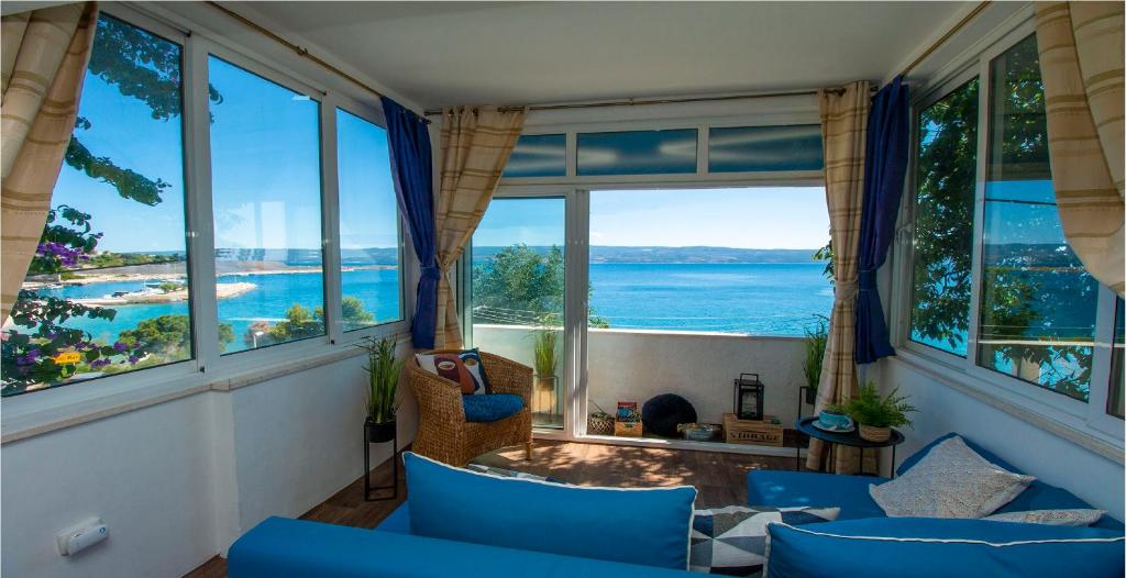 una sala de estar con sillas azules y vistas al océano. en Seaside Lux, en Dugi Rat