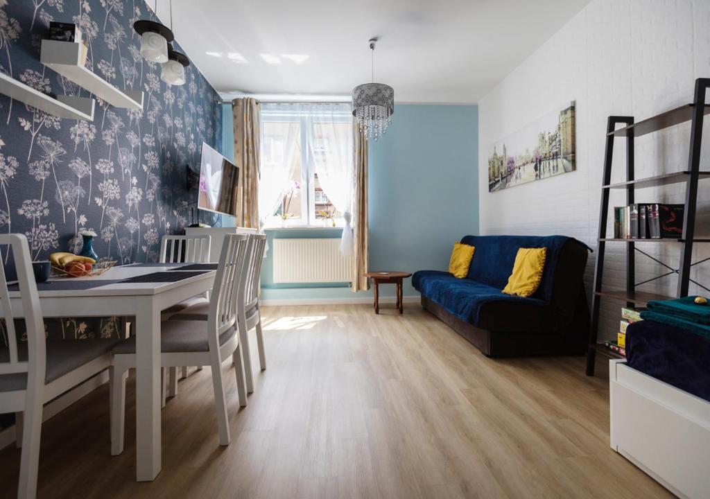 a living room with a table and a couch at Błękitny Apartament in Bytom