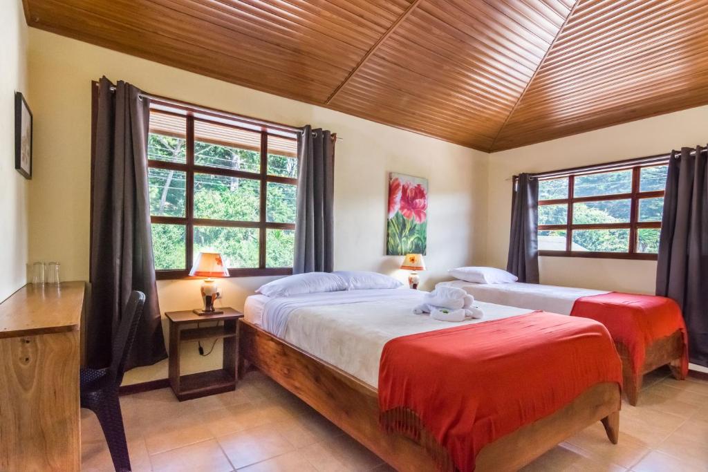 2 letti in una camera con 2 finestre di Hotel Casa Madonna a Monteverde Costa Rica