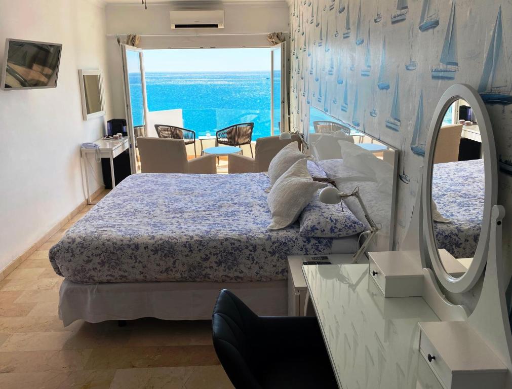 een slaapkamer met een bed en uitzicht op de oceaan bij Hotel Boutique Milla de Plata in Torreguadiaro