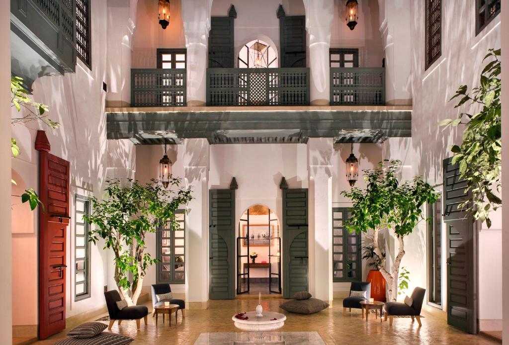 a lobby of a building with chairs and tables at Riad Antara in Marrakech