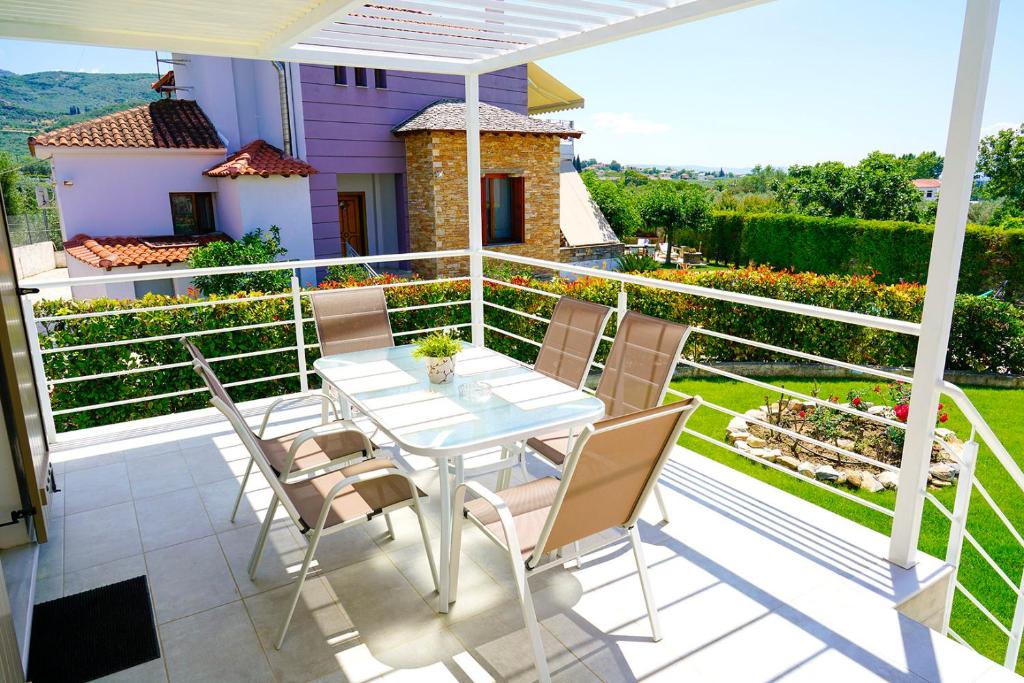 a patio with a table and chairs on a balcony at Charikleia's studio in Káto Lekhónia