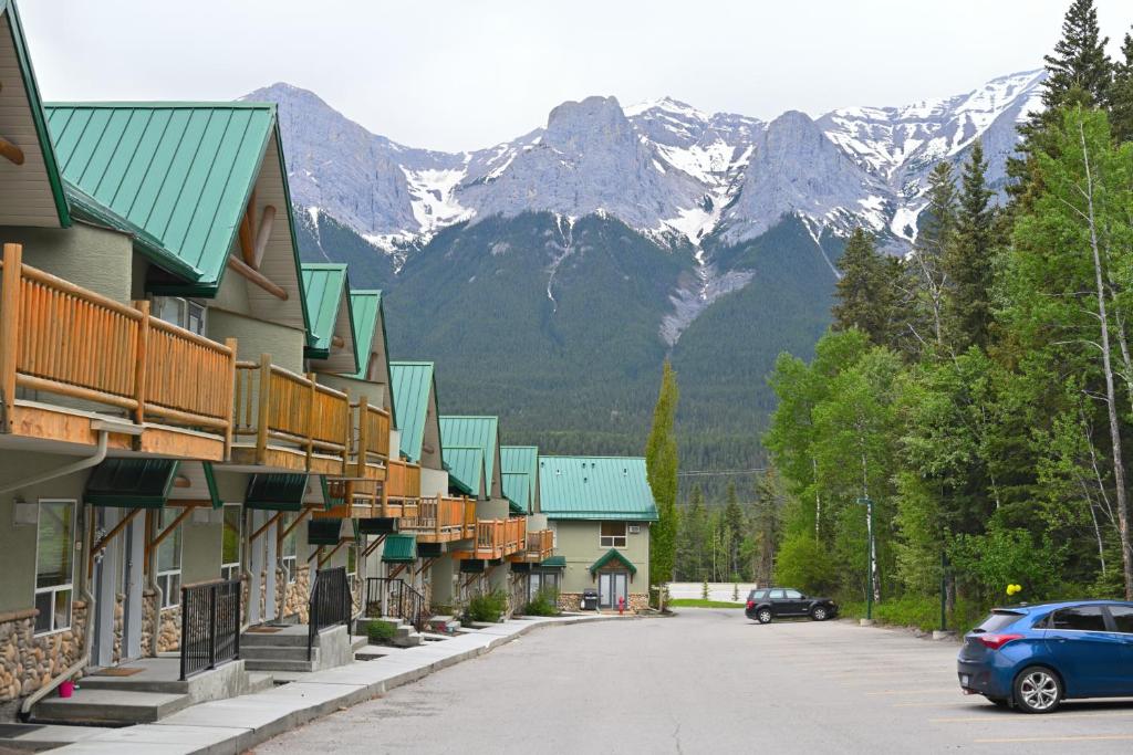 a street in a town with mountains in the background at BANFF WOODS LODGE in Canmore