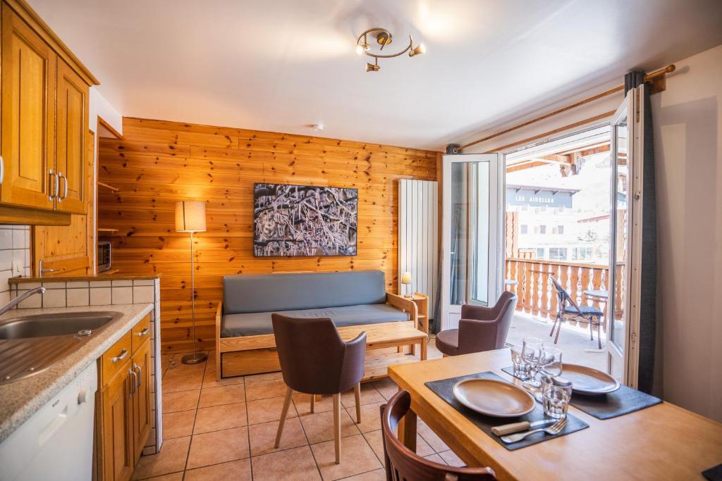 eine Küche und ein Wohnzimmer mit einem Sofa und einem Tisch in der Unterkunft Cellier 4 in Les Deux Alpes