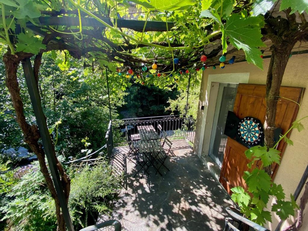une terrasse avec une balançoire et un arbre dans l'établissement Maison les pieds dans l'eau, à Villefort