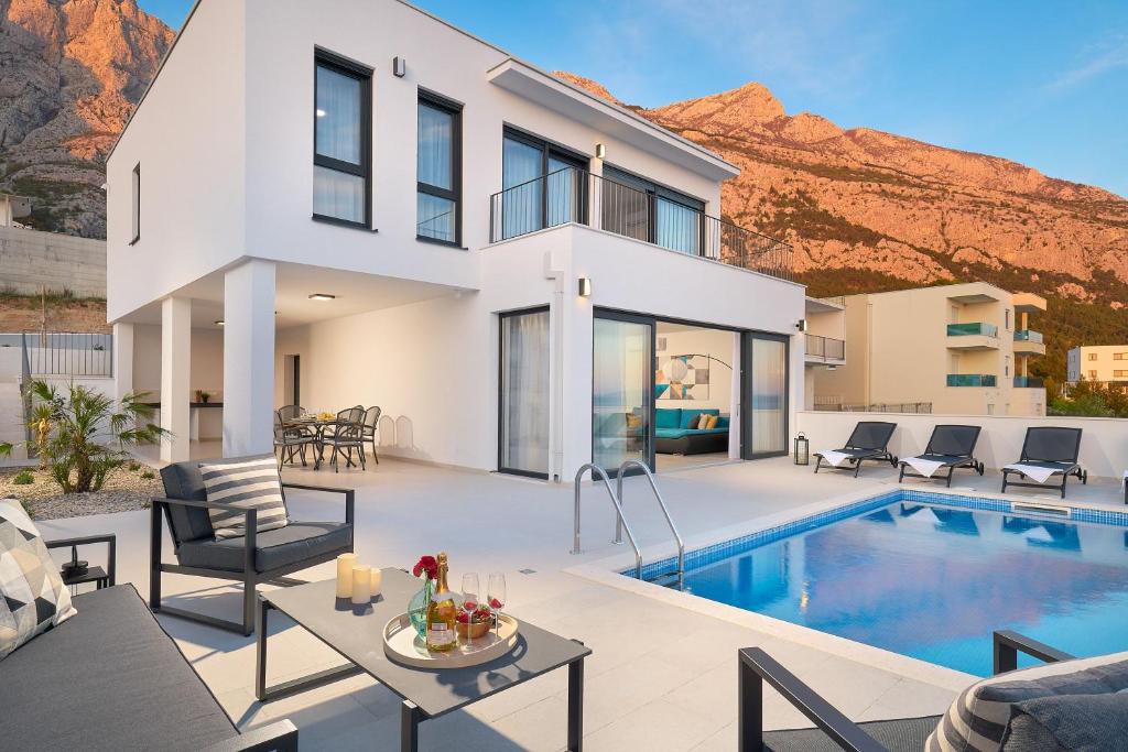 a villa with a swimming pool and a house at Villa Maxima with heated pool - Makarska Veliko Brdo in Makarska