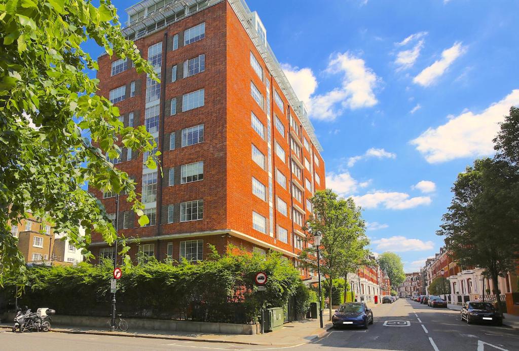 a tall red brick building on a city street at Roland House Apartments in London