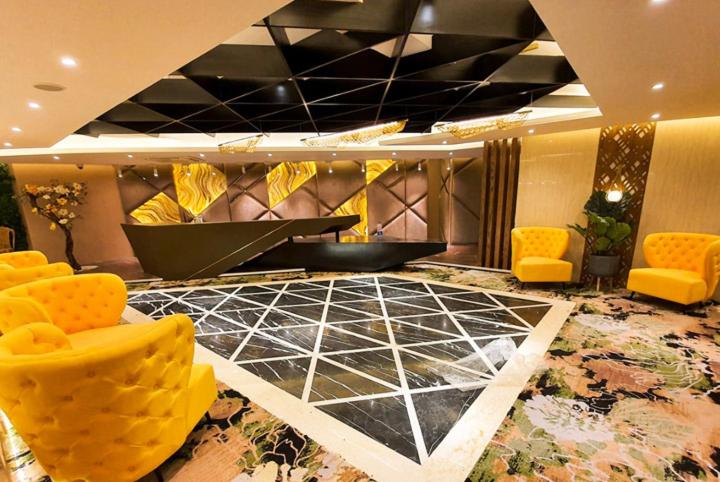 un vestíbulo con sillas amarillas y suelo de baldosa negra en Hotel Star Pacific, en Sylhet