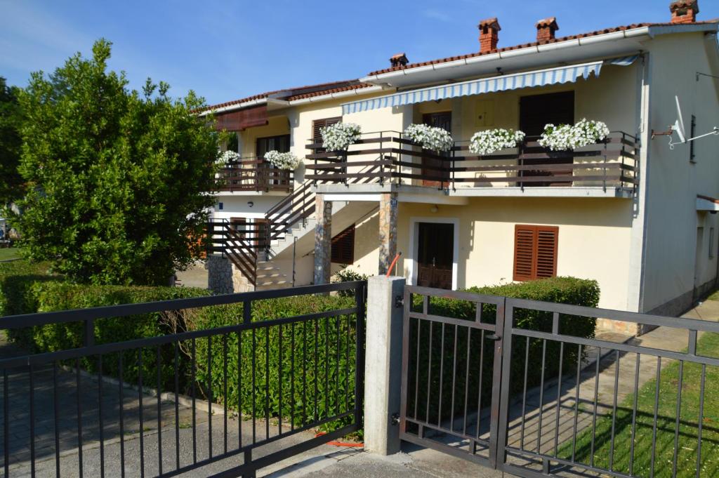 a white house with potted plants on the balconies at Nela in Kršan