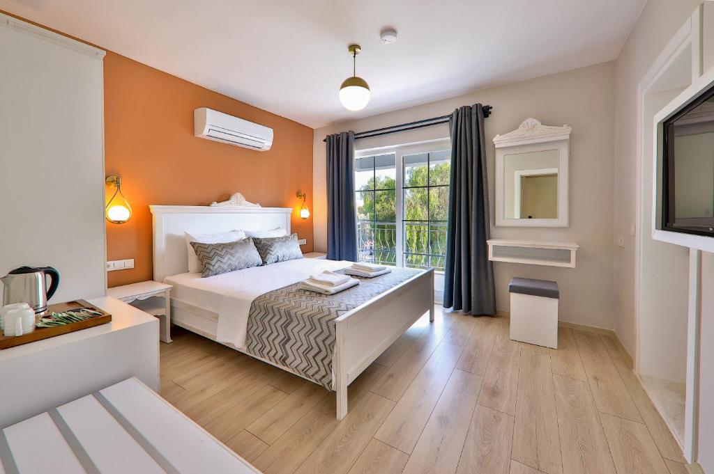 a bedroom with a white bed and a window at Lora Kaş Hotel in Kas