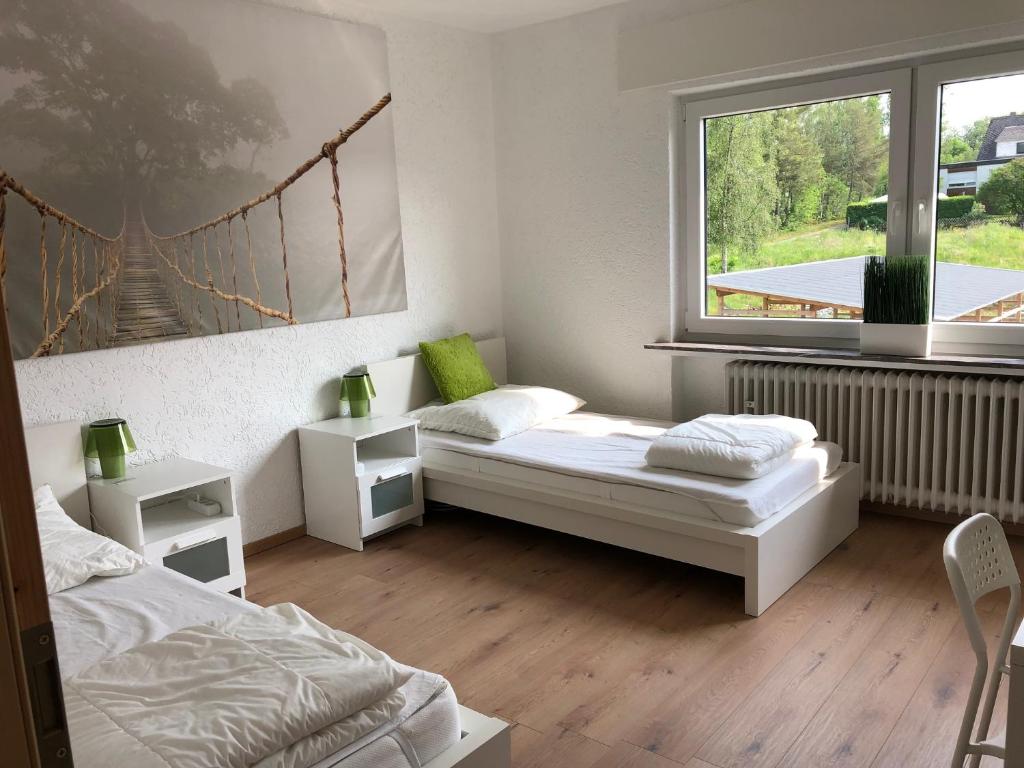 a bedroom with two beds and a large window at Big Ben's Guesthouse in Müllenbach