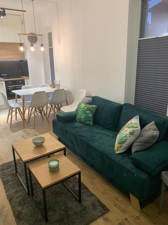 uma sala de estar com um sofá verde e uma mesa em Apartament Joanna em Giżycko