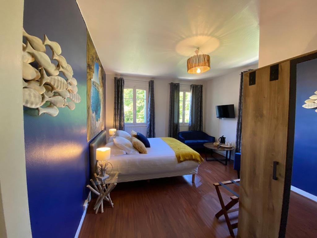a bedroom with a bed and a room with a table at Manoir de la Marjolaine in Cabourg