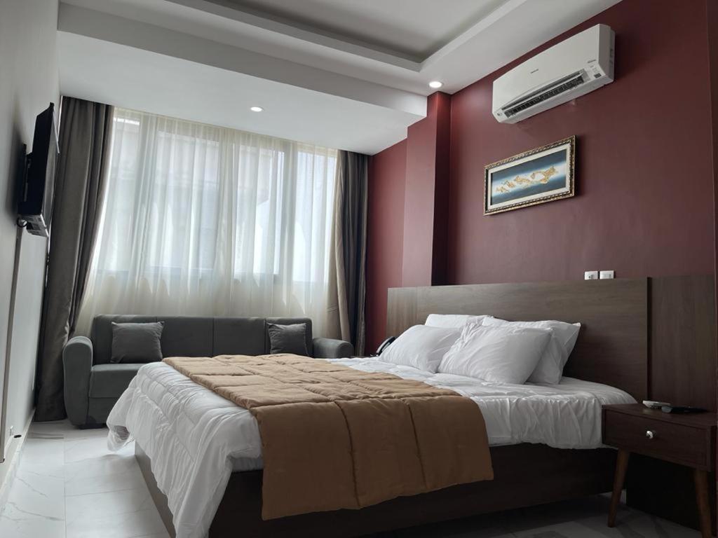 um quarto de hotel com uma cama e um sofá em RESIDENCE SYCOMORE 1 em Abidjan