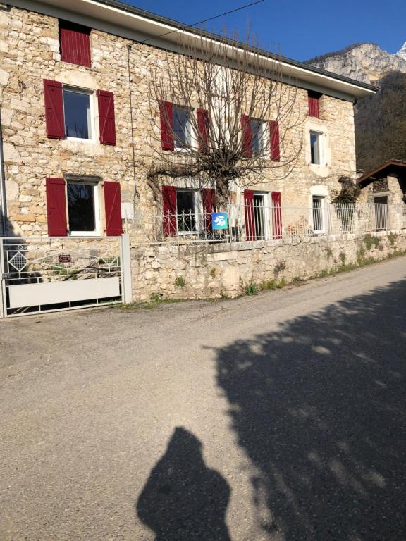 a shadow of a person standing in front of a building at Au vieux four in La Rivière