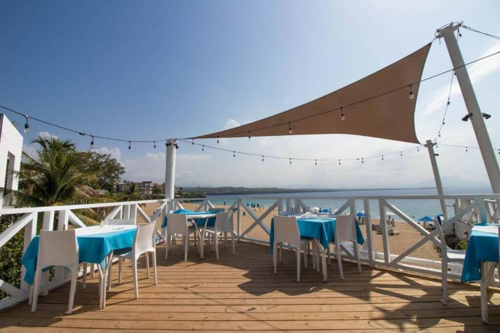 una terraza con mesas y sillas en la playa en Room 8, en Sosúa