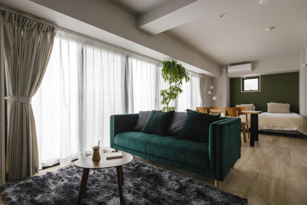 sala de estar con sofá verde y dormitorio en THREE - Vacation STAY 38687v, en Tokio
