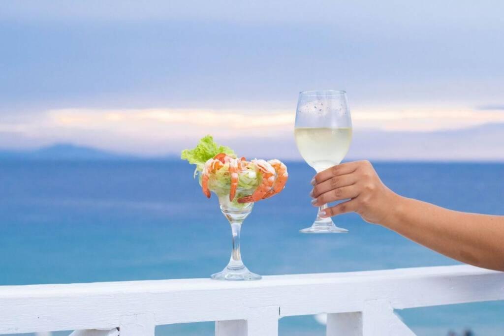 a person holding a glass of wine and a salad at Room 24 in Sosúa