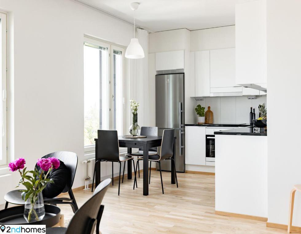 een keuken en een woonkamer met een tafel en stoelen bij 2ndhomes Tampere "Kanava" Apartment - 54m2 Apt with Private SAUNA & Balcony - 11th floor in Tampere