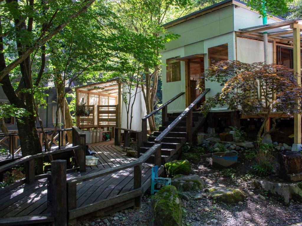 uma casa com um deque de madeira e árvores em Glamping Himeshara - Vacation STAY 43046v em Kirishima