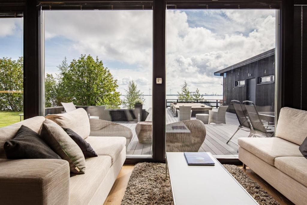 a living room with a couch and a large window at Reelinki Seafront Villa Aava in Pori