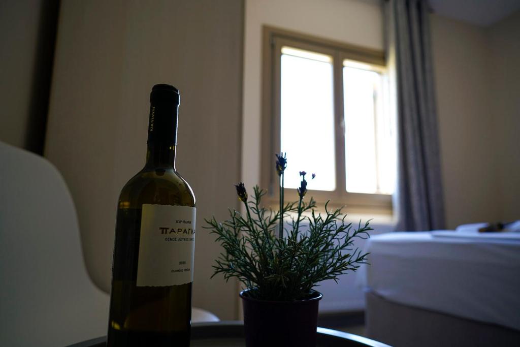 a bottle of wine sitting on a table with a plant at Charikleia's 2 bedroom appartment in Pelion in Volos