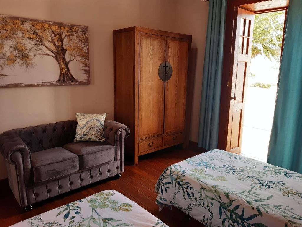 sala de estar con sofá, cama y ventana en Casa rural Los Dragos, en Fuencaliente de la Palma