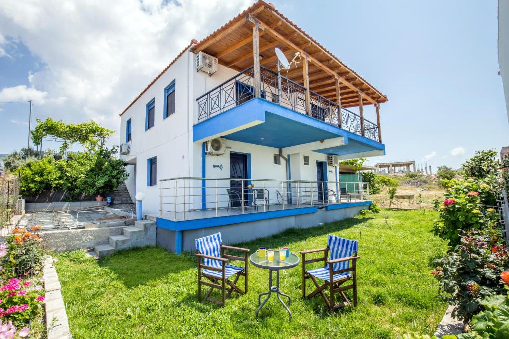 a house with a table and chairs in the yard at Happy villa in Skala Marion