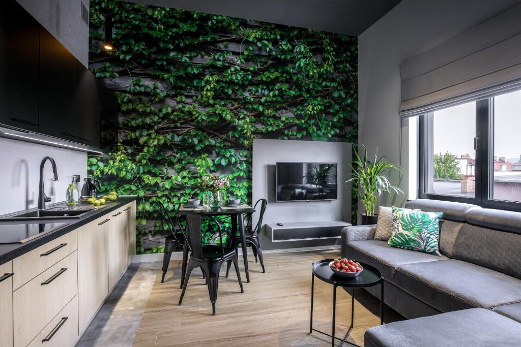 a kitchen and living room with a green wall at Luxo apartments 13 in Jelenia Góra