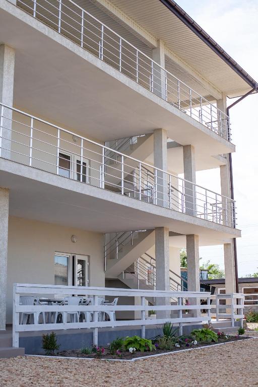 a building with a white railing and a balcony at Estate House in Zatoka