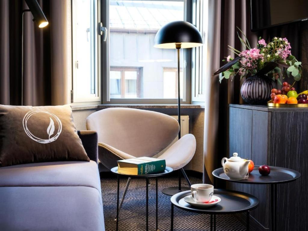 a living room with a couch and two tables at Hotel Logos Kraków in Krakow