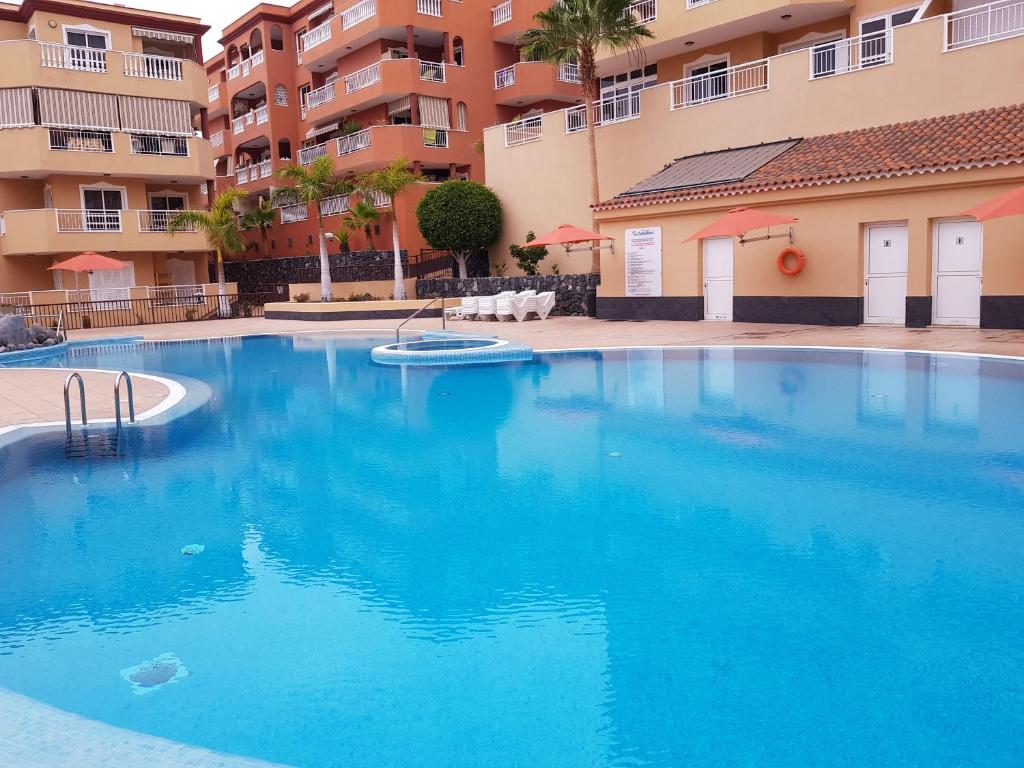 una gran piscina azul frente a un edificio en Ocean View Suite Close to Beach with Pool & WiFi, en Callao Salvaje