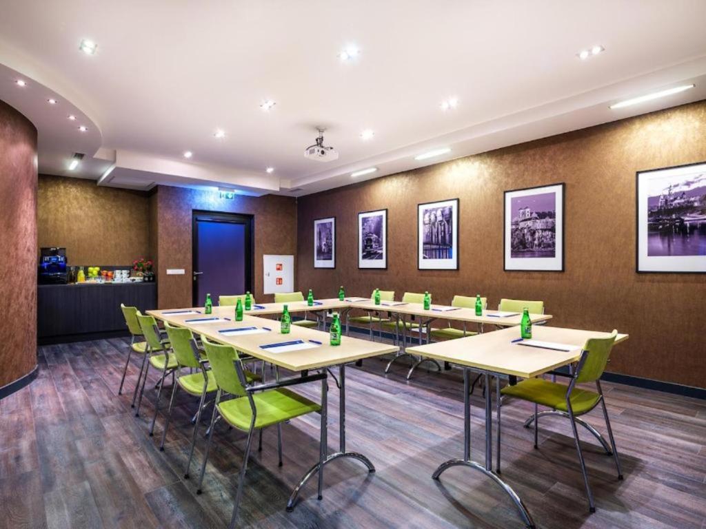 a conference room with tables and green chairs at Hotel Logos Kraków in Krakow
