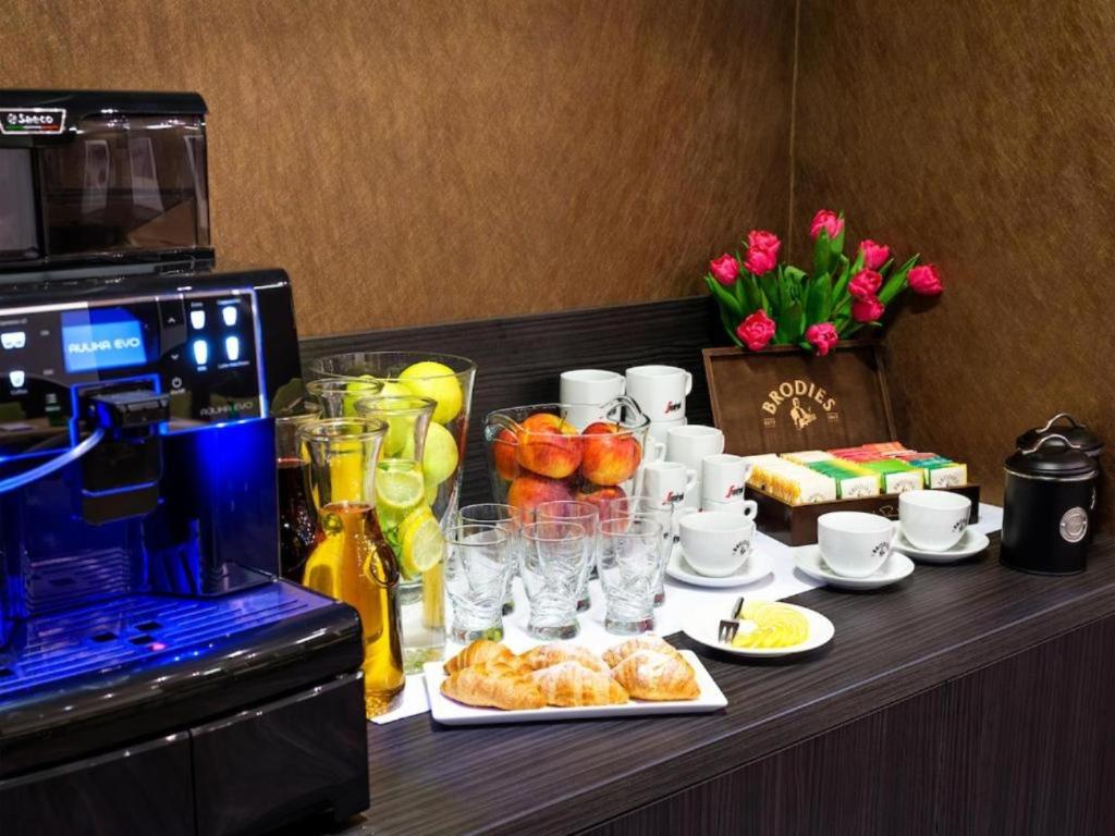 a table with food and drinks and a coffee maker at Hotel Logos Kraków in Krakow
