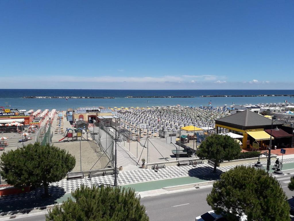 a beach with a lot of umbrellas and the ocean at Hotel Real in Cesenatico