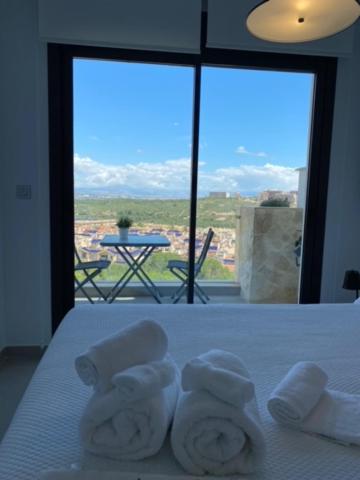 Una habitación de hotel con una cama con toallas. en Luxury sea view MARGOAPARTMENTS, en Gran Alacant