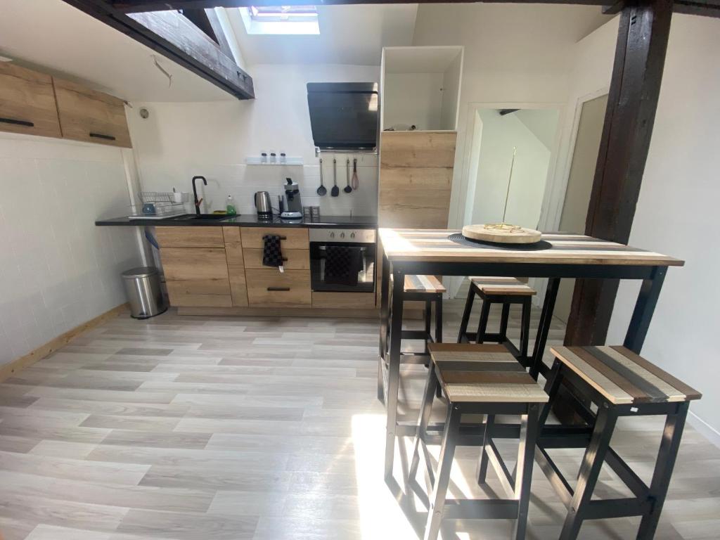 cocina con mesa y sillas en una habitación en Jolie Appartement 2 chambres a dunkerque, en Saint-Pol-sur-Mer
