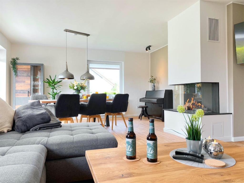 een woonkamer met een bank en een tafel met wijnflessen bij Ferienhaus Weserbrandung in Nordenham