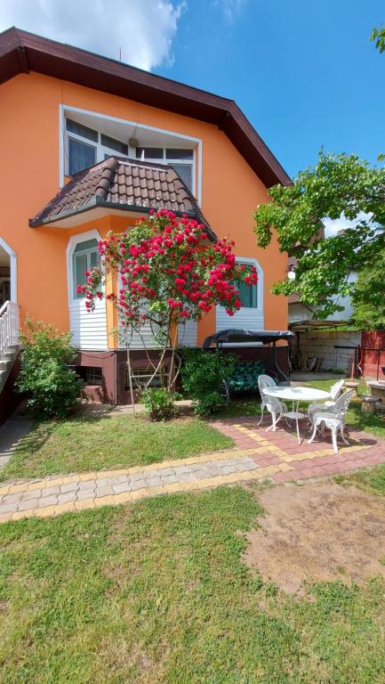 una casa con una mesa y un banco delante de ella en Laci Magánszálláshely, en Debrecen