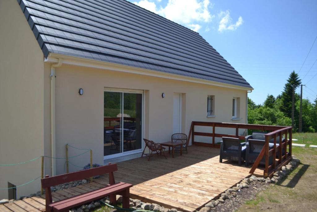 ein Haus mit einer Terrasse mit Bänken darauf in der Unterkunft Maison Cinona in Le Mont-Dore