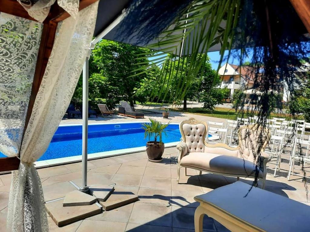 a patio with a swing and a swimming pool at Caballus Lovasmajor in Nyíregyháza