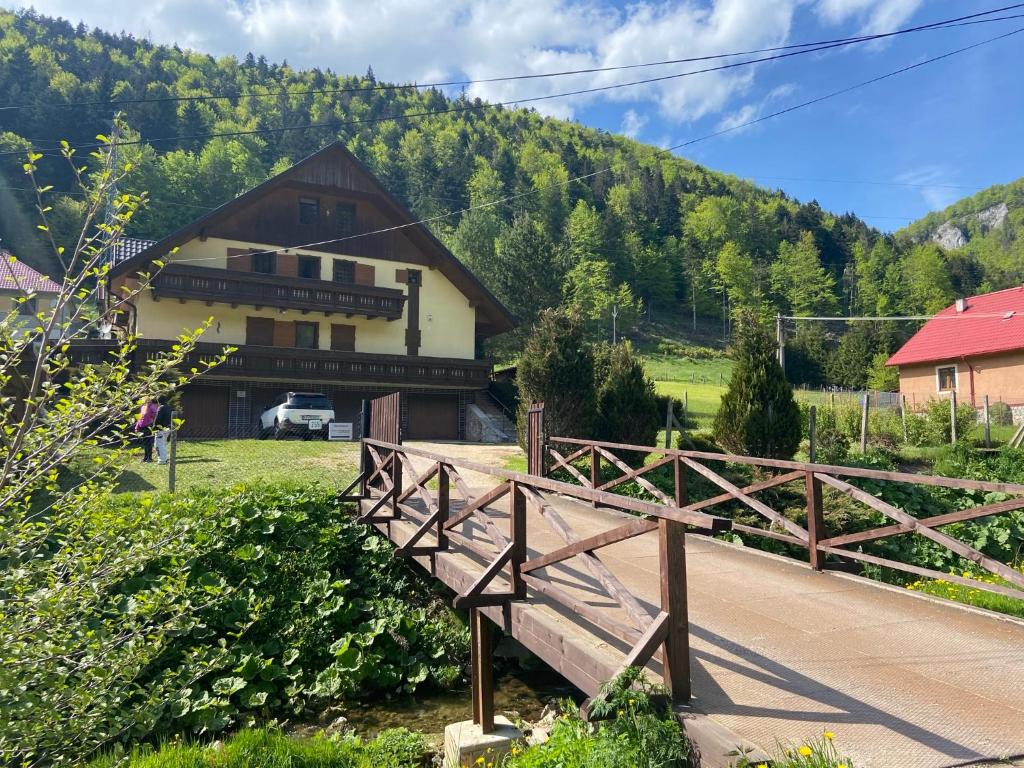 a wooden bridge in front of a house at Ubytovanie v súkromí - Chata Zejmarka in Mlynky 