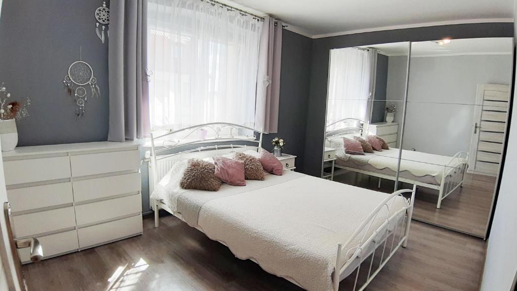 a bedroom with a bed and a mirror at Sea&Wine Apartamenty Darłówko in Darlowko
