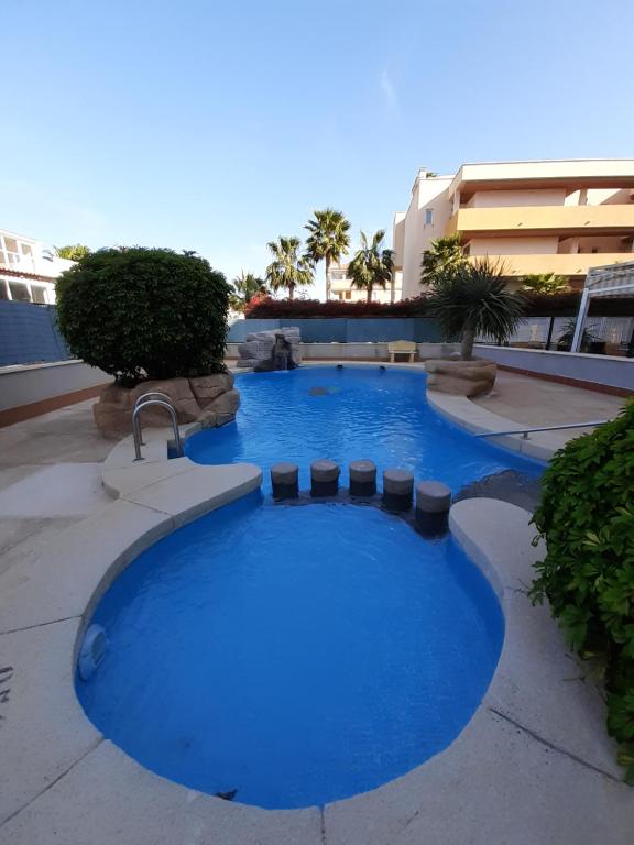 einen großen Pool mit blauem Wasser im Innenhof in der Unterkunft Apartamento ROMERO Cabo Roig, solárium opcional in Orihuela