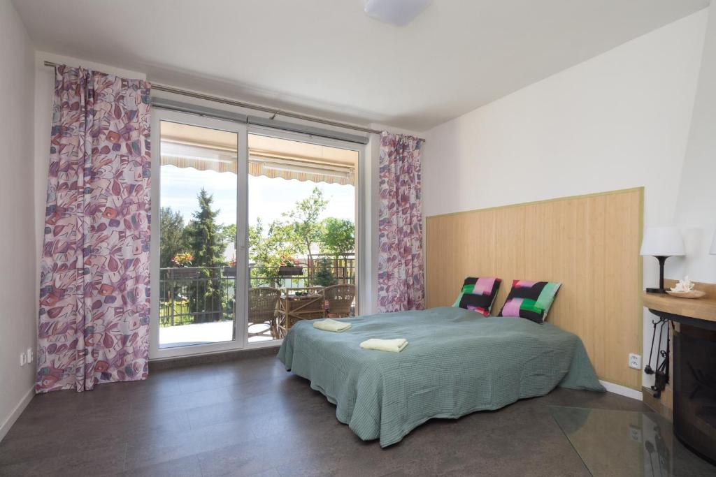 ein Schlafzimmer mit einem Bett und einem großen Fenster in der Unterkunft Sunny apartment in Olomouc