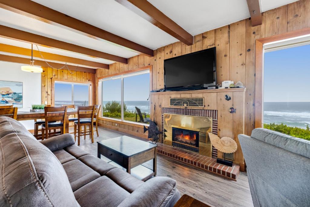 a living room with a fireplace and a television at Sea Castle BeachFront Getaway in Lincoln Beach