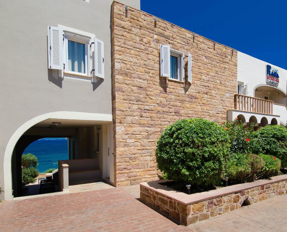 a building with a stone wall and a doorway at Plaka Studios in Karfas