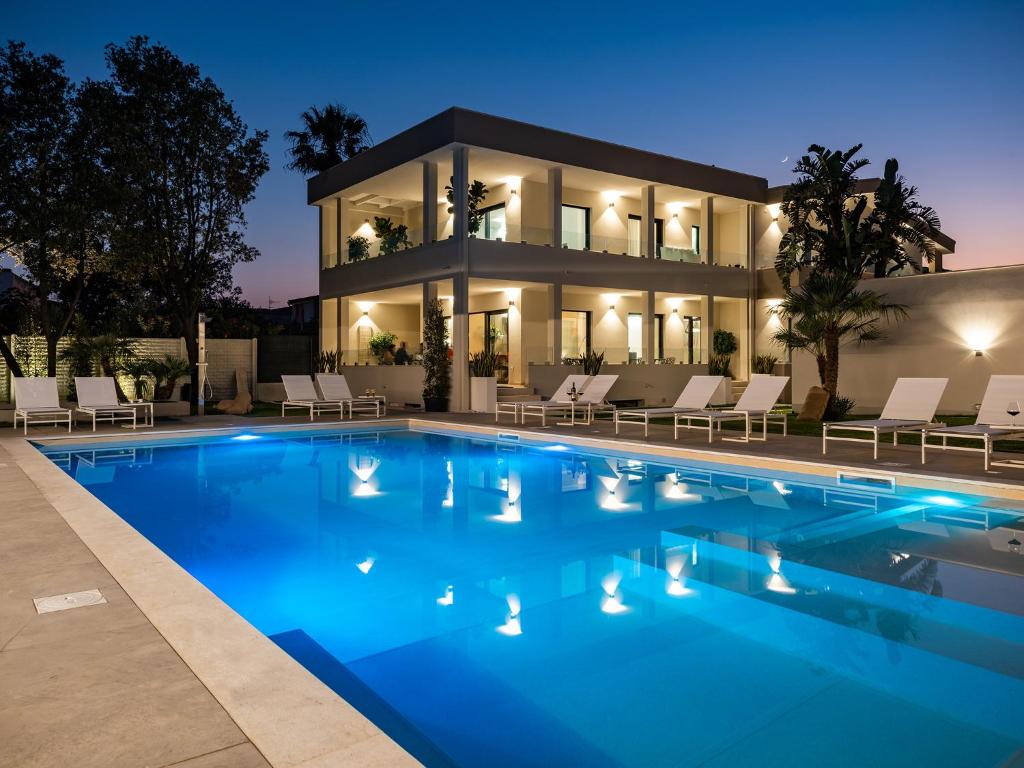 a villa with a swimming pool at night at Palazzo Michelangelo in Villasimius